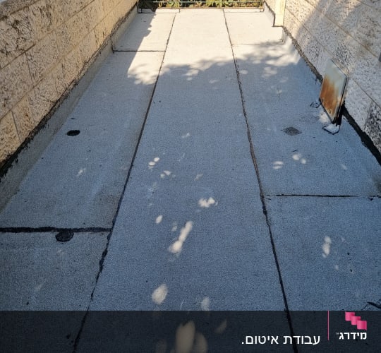 משטח אטום עם חומר איטום שחור בין לוחות בטון